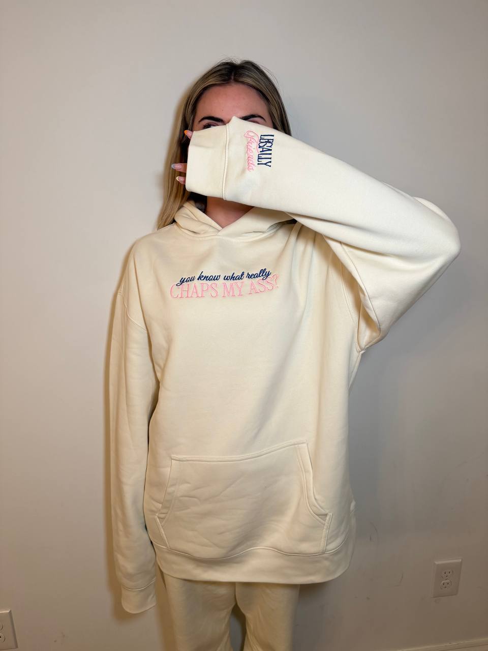 Cream Legally Friends Chaps My Ass hoodie modeled with front graphic and sleeve detail