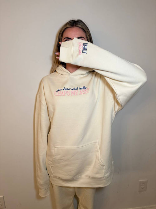 Cream Legally Friends Chaps My Ass hoodie modeled with front graphic and sleeve detail